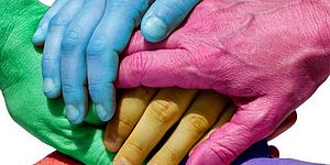 mani colorate che si stringono