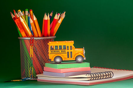 matite e libri e un piccolo mdellino di scuolabus